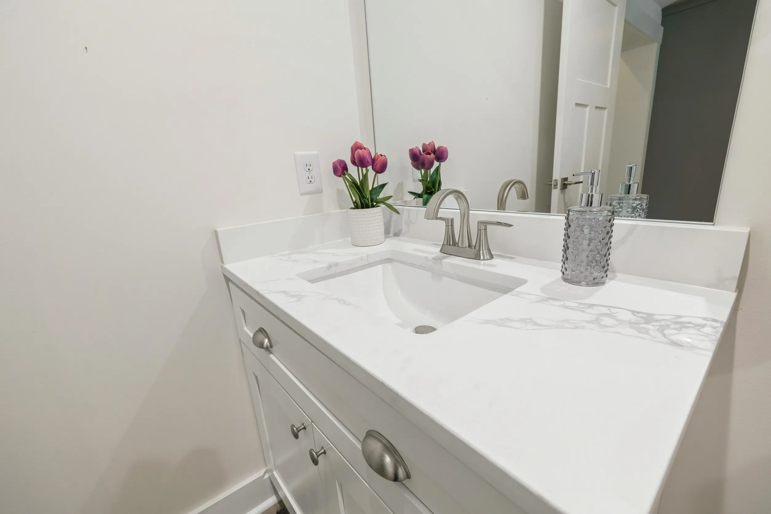 紫色のチューリップが飾ってる洗面化粧台